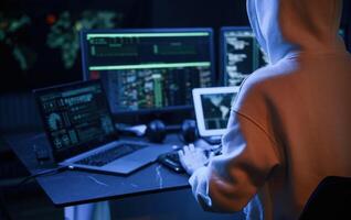 Blue ,neon, light. Young professional female hacker is indoors by computer with lot of information on displays photo