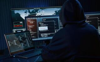 Dark, room. ,Young professional female hacker is indoors by computer with lot of information on displays photo