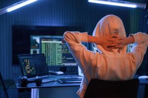 Looking, at ,screens. Young professional female hacker is indoors by computer with lot of information on displays photo