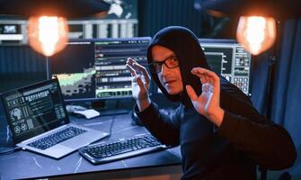 Got, caught. With hands up. Male professional hacker is sitting by computer, conception of virus photo
