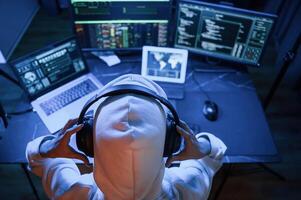 Top view. Young, professional female hacker is indoors by computer with lot of information on displays photo