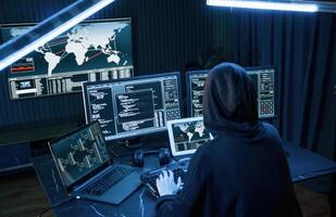 Information, on ,screens. Young professional female hacker is indoors by computer with lot of information on displays photo