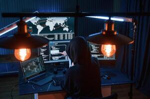 Information, on, screens. Young professional female hacker is indoors by computer with lot of information on displays photo