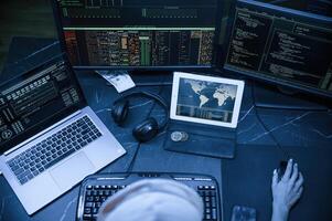 Top view.. Young, professional female hacker is indoors by computer with lot of information on displays photo