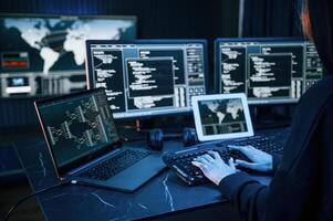 Information, on, screens.. Young professional female hacker is indoors by computer with lot of information on displays photo
