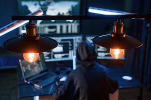 Light bulbs., Young ,professiona,l female hacker is indoors by computer with lot of information on displays photo