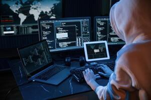 View, from, behind. Young professional female hacker is indoors by computer with lot of information on displays photo