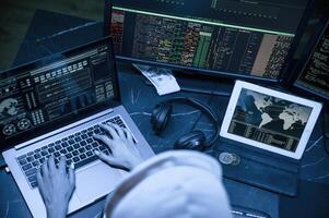 Blue ,neon light.. Young professional female hacker is indoors by computer with lot of information on displays photo