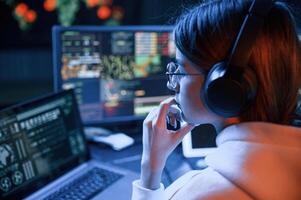 Focused, on ,work. Young professional female hacker is indoors by computer with lot of information on displays photo