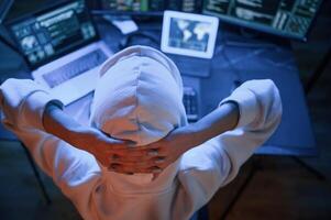 Top view. .Young professional female hacker is indoors by computer with lot of information on displays photo