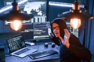 Got, caught. .With hands up. Male professional hacker is sitting by computer, conception of virus photo