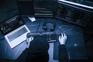 Male professional hacker is sitting by computer, conception of virus photo