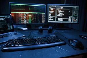 Keyboard and screens.. Cyber criminal haker dark room for massive attack of corporate big data servers photo