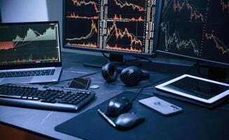 Financial Analyst Working on a ,Computer ,with Multi-Monitor Workstation with Real-Time Stocks, Commodities and Exchange Market Charts. photo