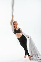Beautiful ,woman is standing, and holding the canvas. Conception of fly yoga. Against white background photo