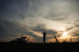 Silhouette of a man that is in the, field at sunset time. Dramatic sky photo