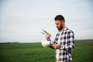 Spring, season. .Handsome young, man is on agricultural field photo