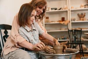 In the workshop.. Mother ,with little girl ,making ceramic pot photo