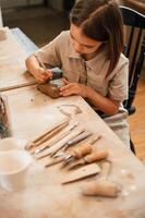 Different, tools on the table. Little girl is learning how to do pottery in the workshop photo