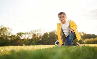 On the ground. Boy is on the summer field ,with soccer ball photo