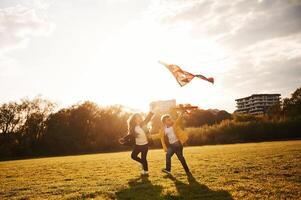 Two kids are playing with ,kite on ,the summer field photo