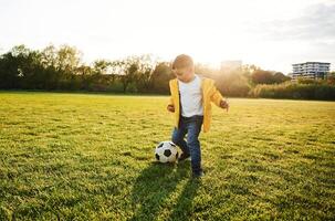 Boy is on the summer field with soccer ball photo