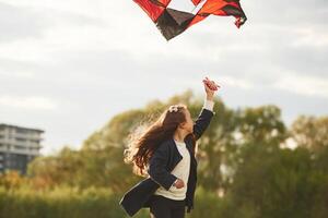 Happy ,little girl is playing with kite on the summer field photo