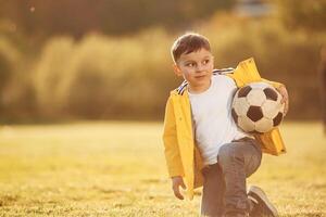 Front view. .Boy is on the summer field with soccer ball photo