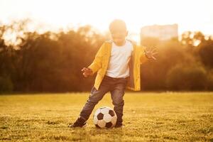 Front, view.. Boy is on the summer field with soccer ball photo
