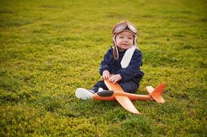 Little boy, is with toy plane on the summer field photo