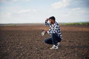 Digital ,tablet in hands. On cultivated agricultural field. Handsome Indian man photo