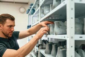 Raw shoe parts for the prosthesis. Man is choosing size photo