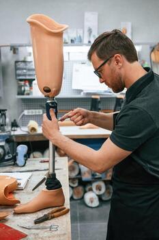 Assembles ,the prosthesis, using tool.. Technician working in modern laboratory photo