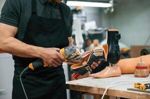 Cuts, the ,material with drill. Technician working with prosthesis in modern laboratory photo