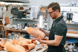 Using marker to draw the line. Technician working with prosthesis in modern laboratory photo