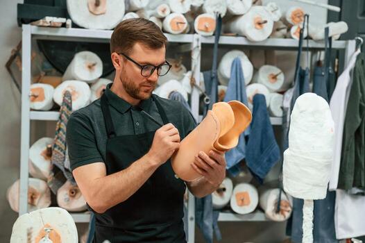 Marks ,the line with a marker.. Technician working with prosthesis part in modern laboratory photo