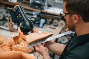Measuring the prosthesis. Technician working in, modern laboratory photo