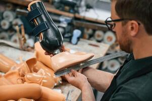 Measuring the prosthesis. Technician working in modern ,,laboratory photo