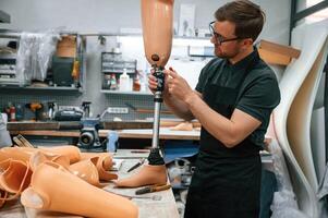 With ,prosthesis, in hands. Technician ,working with prosthesis in modern laboratory photo
