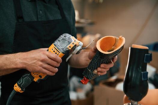 Cuts the material with,, drill. Technician working with prosthesis in modern laboratory photo