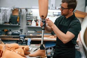 With prosthesis ,in hands. Technician working with prosthesis in modern laboratory photo