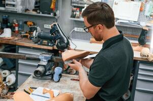 Standing, checking, measure of the prosthesis. Technician working in modern laboratory photo