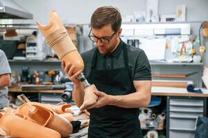 Technician working with prosthesis, in modern laboratory photo