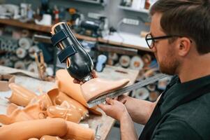 Measuring the prosthesis. Technician ,working in modern laboratory photo