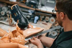 Measuring ,the prosthesis. Technician working in modern laboratory photo