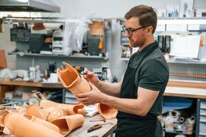 Using ,marker to draw the line. Technician working with prosthesis in modern laboratory photo