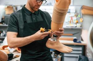 Tightening the ,screws. Technician working with prosthesis in modern laboratory photo