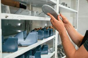 In search, for right size for the ,shoe. Man is working indoors photo