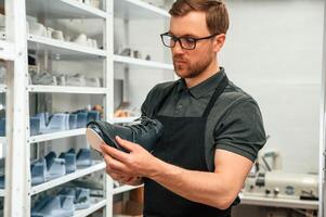 In search ,for, right size for the shoe. Man is working indoors photo