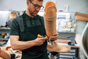 Tightening the, screws. ,Technician working with prosthesis in modern laboratory photo